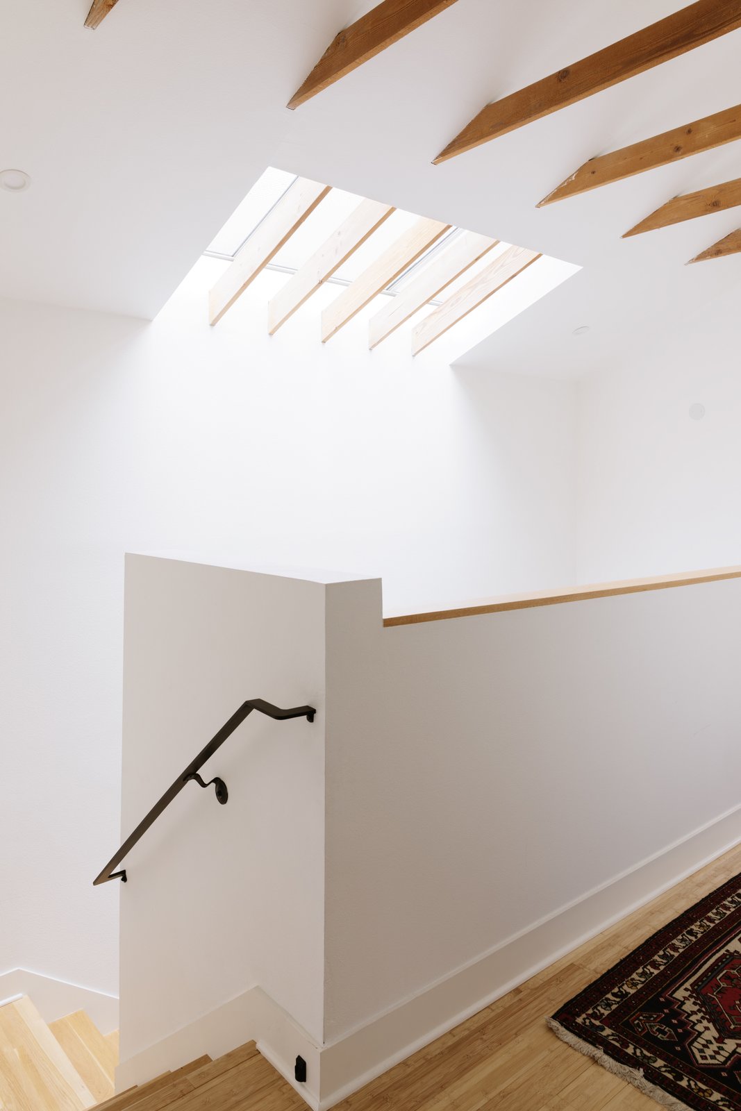 the stairs and landing are warmed by a skylight which directs light throughout different levels of the home