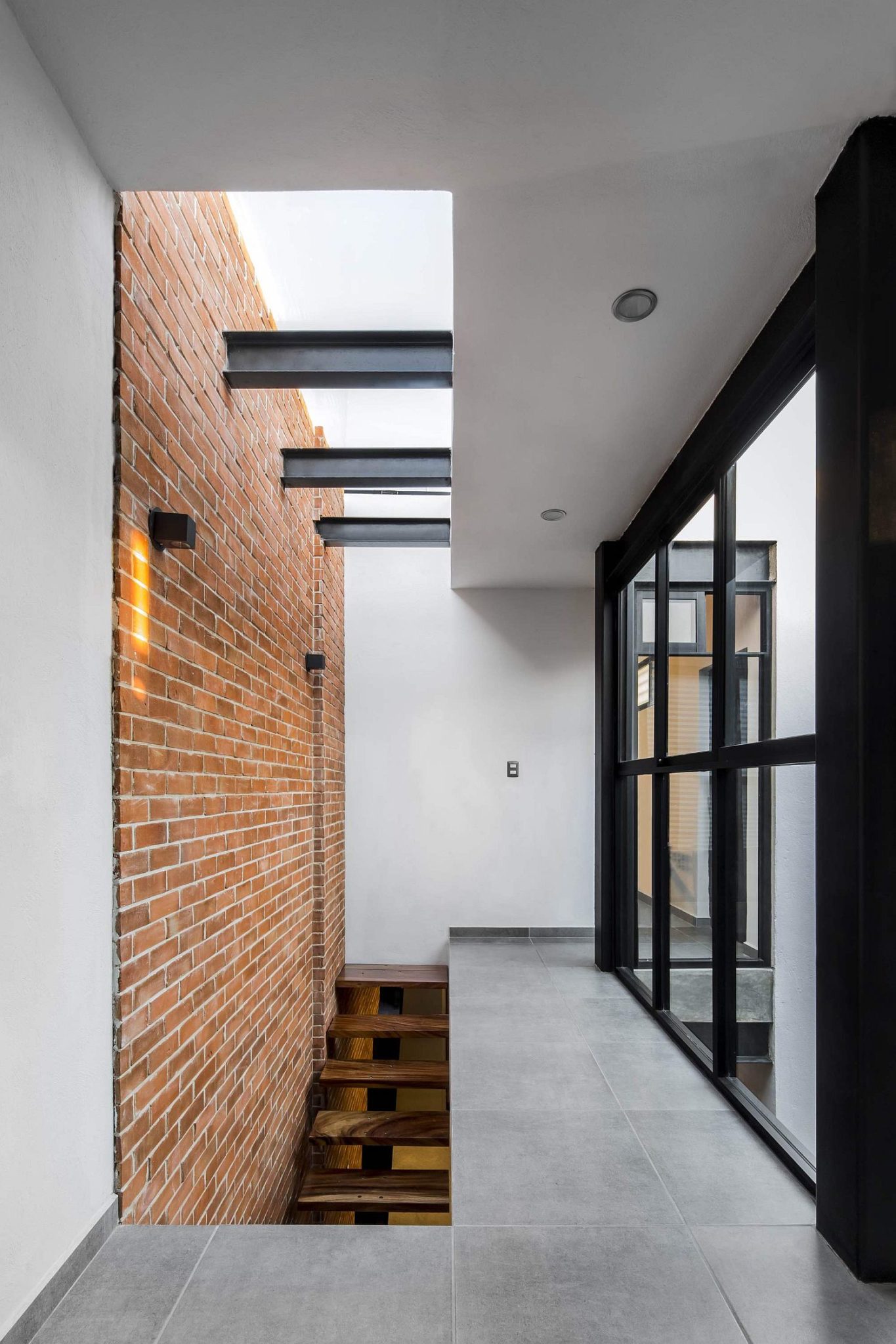 Stairwell and skylight bring natural light into the industrial modern home